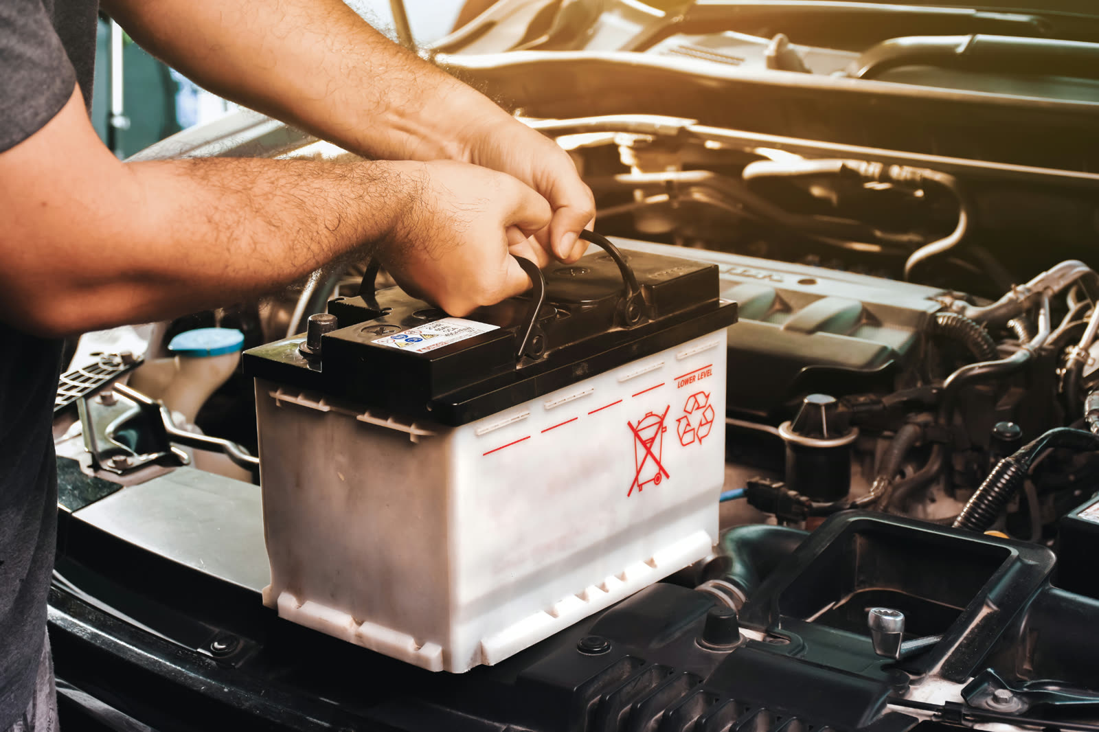 Technician testing a car battery before winter