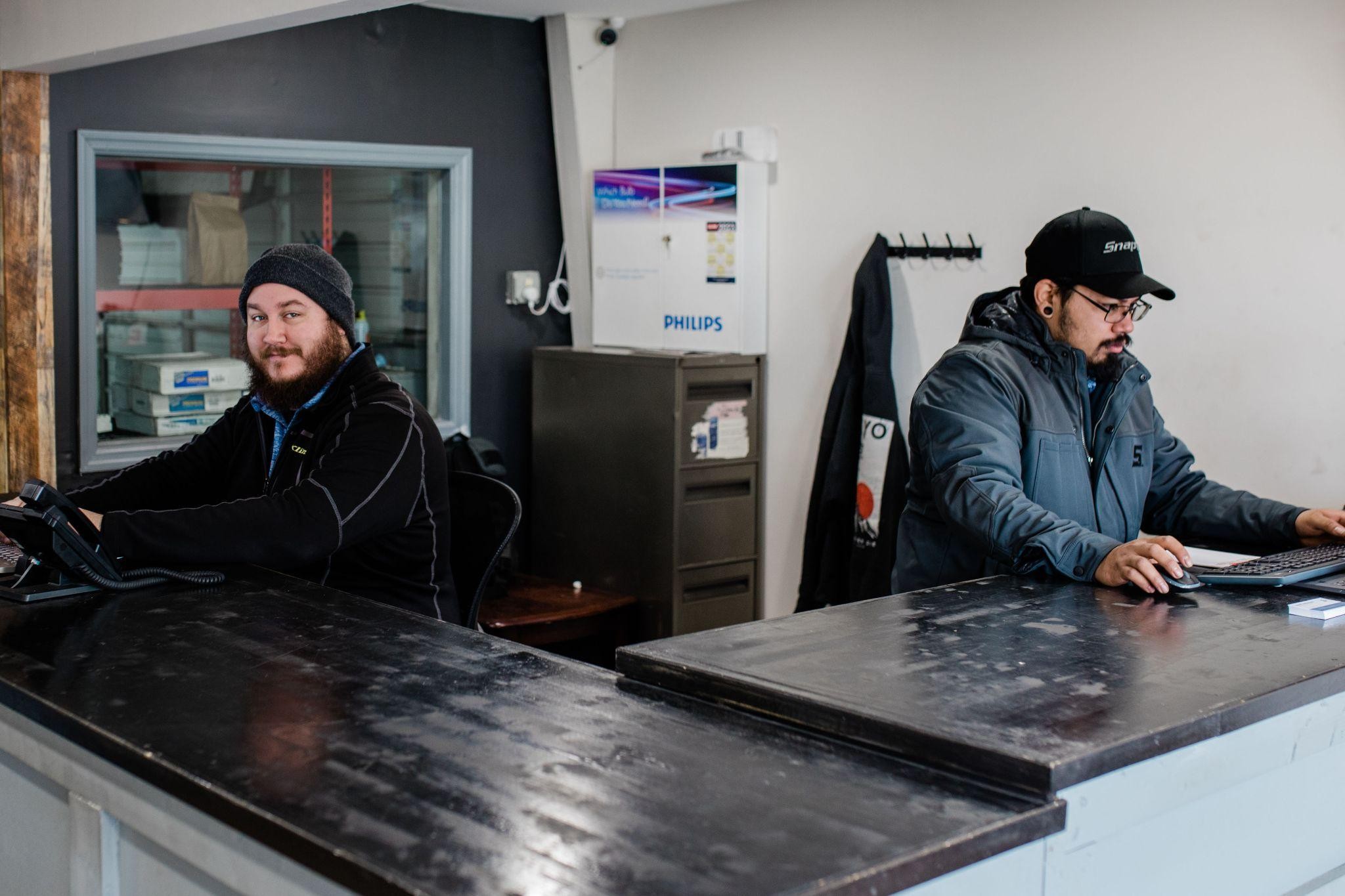 Two mechanics working at a service counter