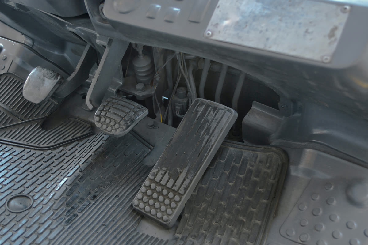 Driver pressing a brake pedal that feels weak and unresponsive