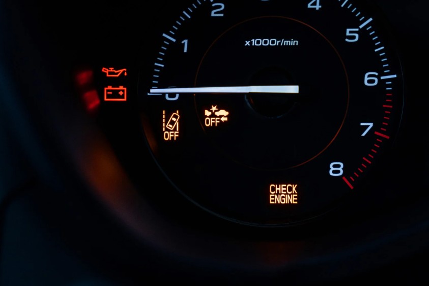 Car tachometer with several illuminated warning lights, including a check engine light