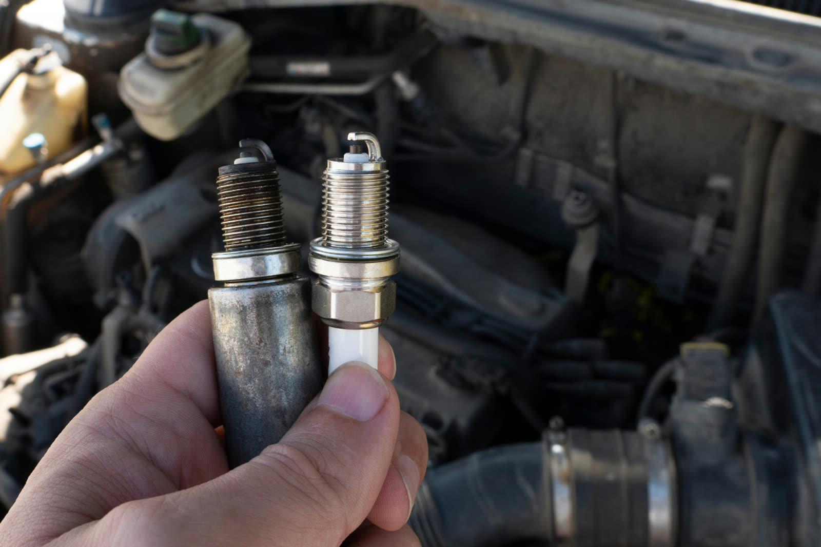 Worn spark plugs being replaced during an engine tune-up