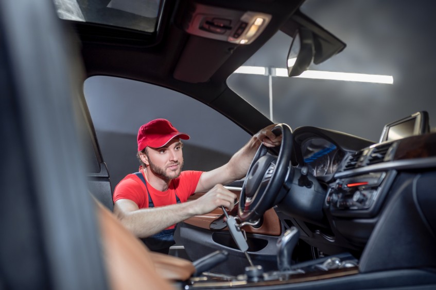 Technician performing a diagnostic check on a vehicle dashboard