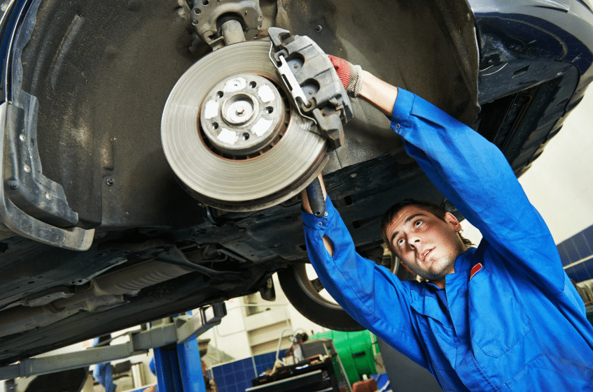 Blue Ridge Automotive | Atlanta Brake Services: Types, Signs, and Repair Options Auto mechanic performing a brake repair on a lifted vehicle in a service shop.