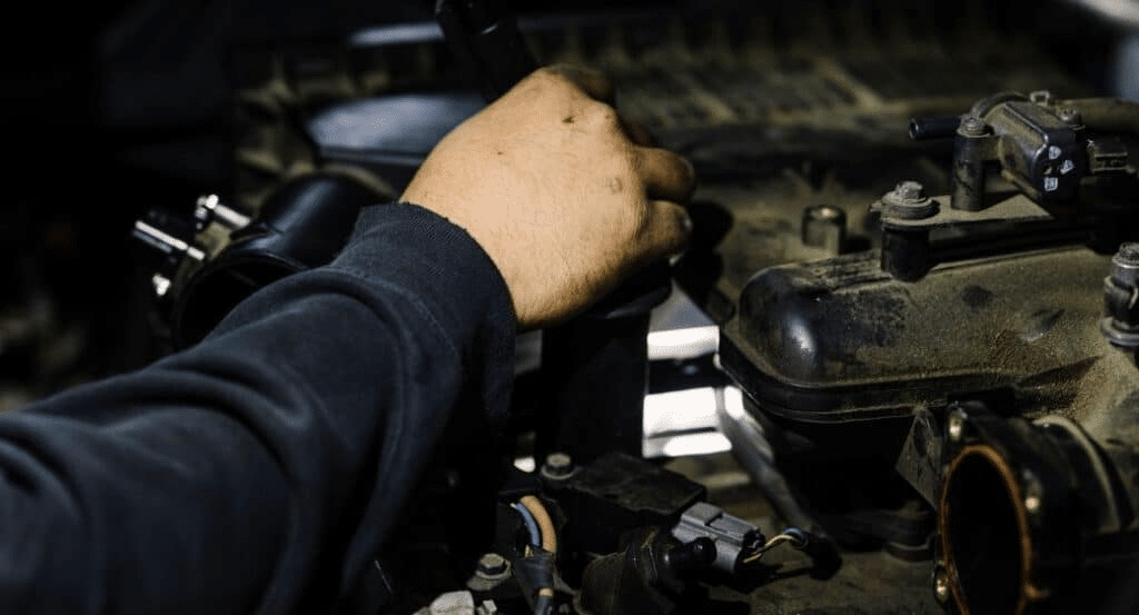 Close-up of mechanic's hand during engine inspection to resolve diagnostic trouble codes.