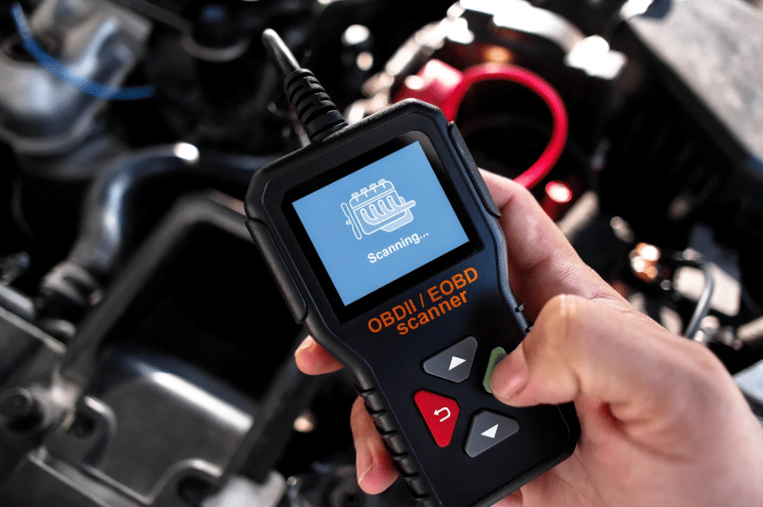 Modern OBDII scanner diagnosing a vehicle, showing how the history of auto mechanics evolved with technology.