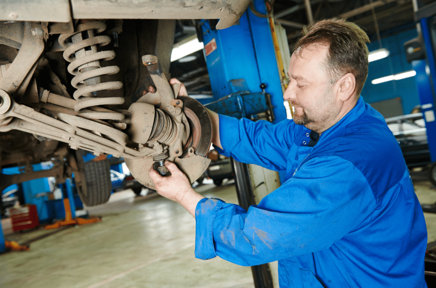 Blue Ridge Automotive | Why a Suspension Check Matters: Protect Tire Life and Vehicle Safety Mechanic examining suspension components on a vehicle lift as part of a suspension check.